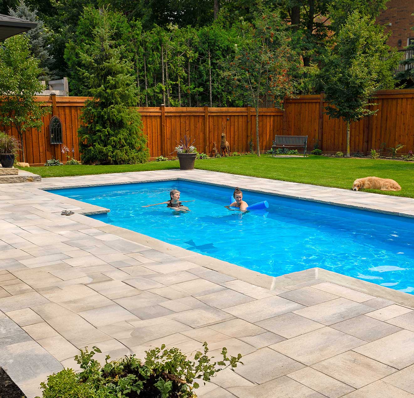 A beautiful sparkling pool in the backyard of a house.