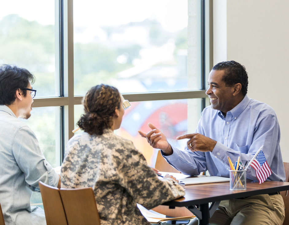 Banking advisor speaking to a couple about Dover Federal Credit Union’s military and veteran no-fee accounts, veteran-focused loans, and personalized financial guidance.