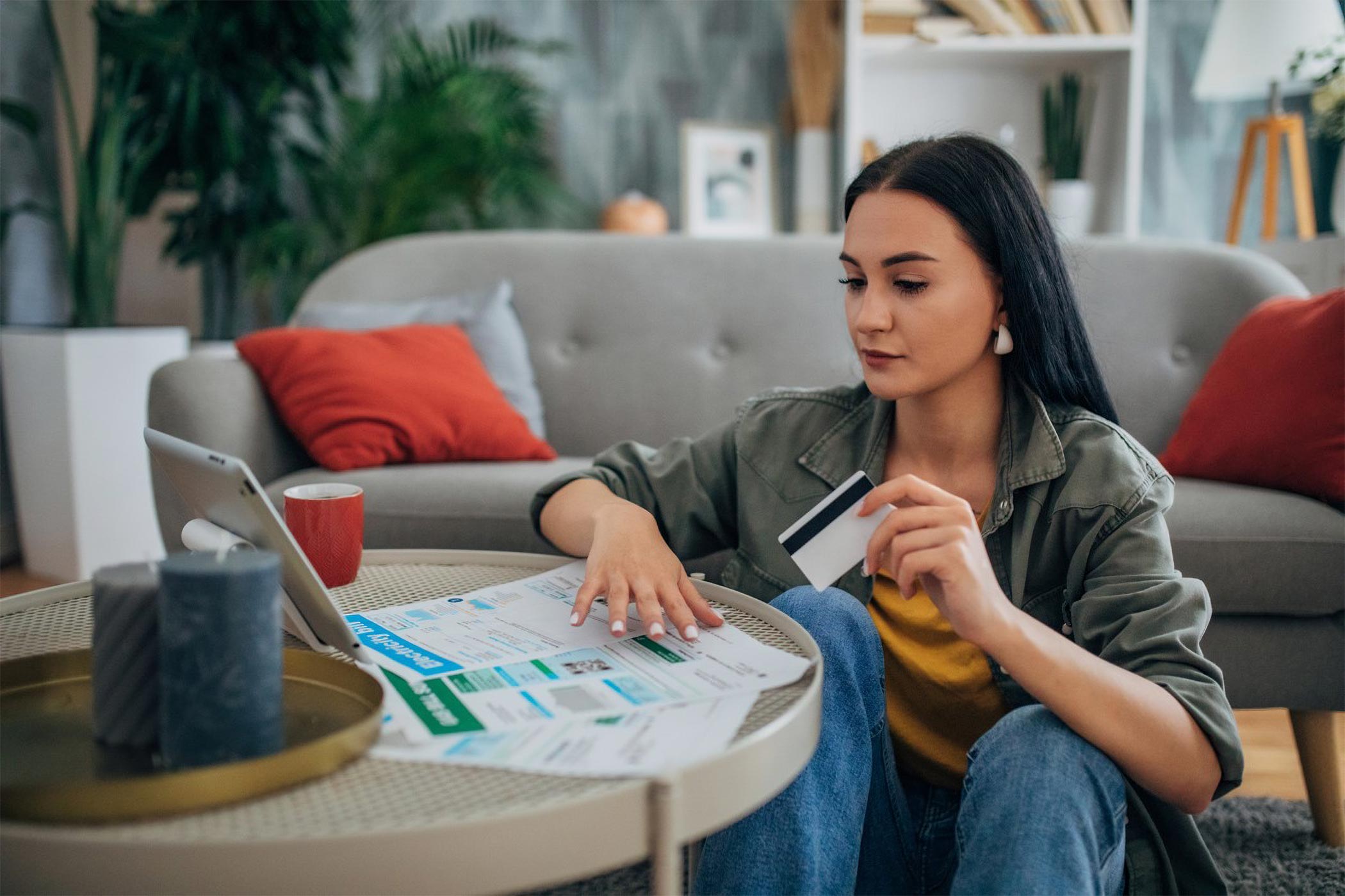 Woman using her Dover Federal Credit Union Credit Card having financial peace of mind reviewing her budget.